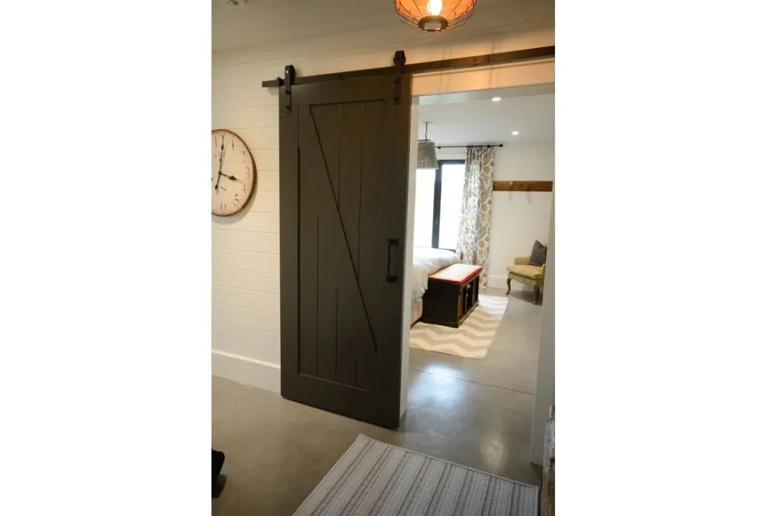 Custom wooden barn door designed by Homestead Woodworks, providing a rustic and stylish touch to the home's interior